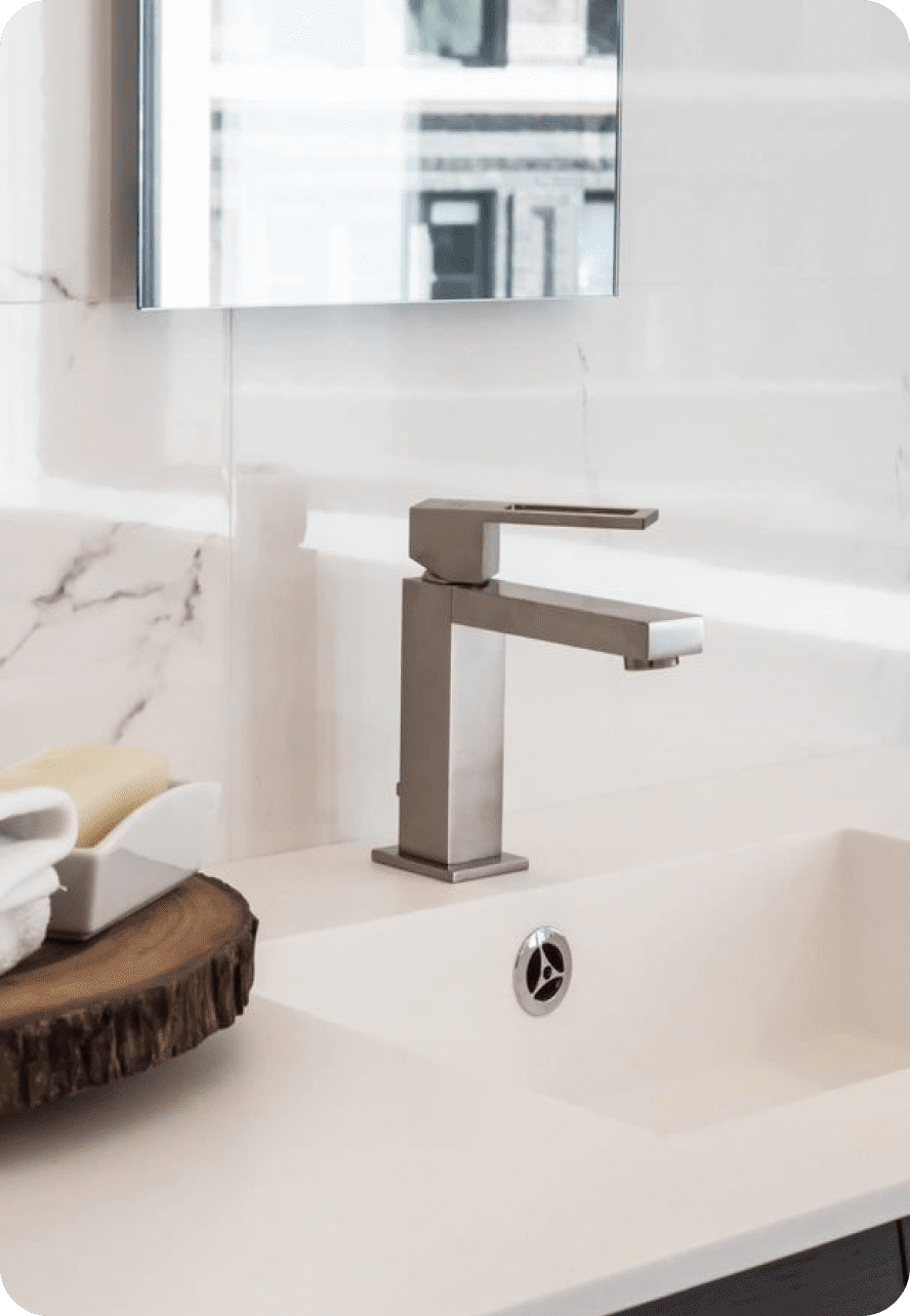Modern bathroom faucet with a sleek, rectangular design on a white sink.
