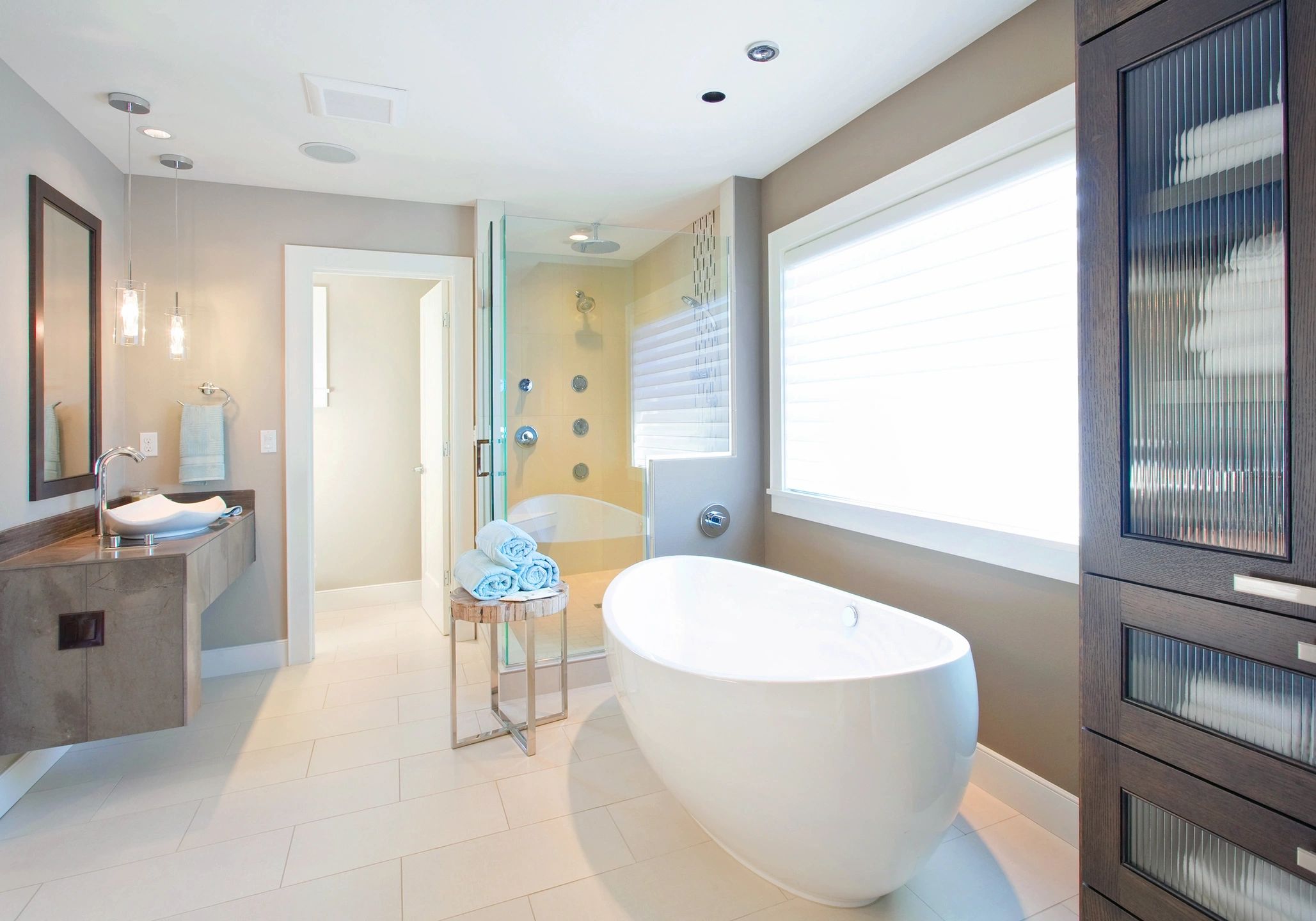 Modern bathroom with a freestanding bathtub and large window.