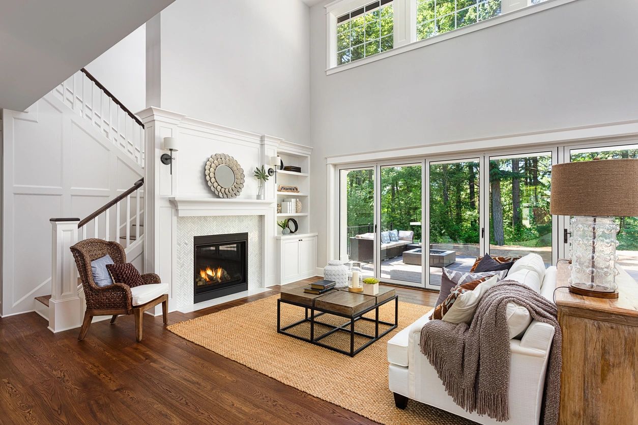 Bright and cozy living room with fireplace and large windows.