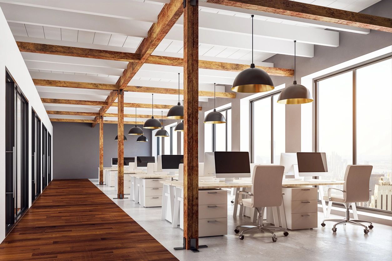 Modern office space with wooden beams and white desks.