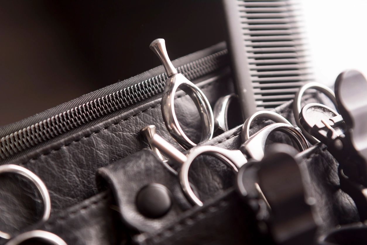 Close-up of hairdressing scissors in a leather case.